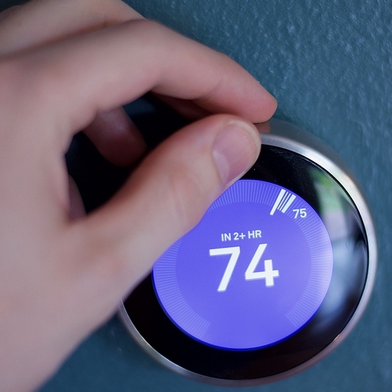 person setting thermostat to 74 degrees